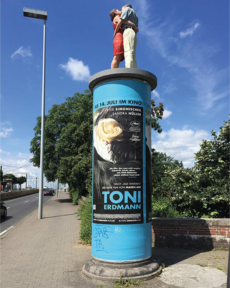 Die 1,90 m grosse Originalskulptur auf einer Litfass-Säule ist in Düsseldorf zu sehen. Statuette eines Paares auf einer bunten Säule an einer Straßenecke.