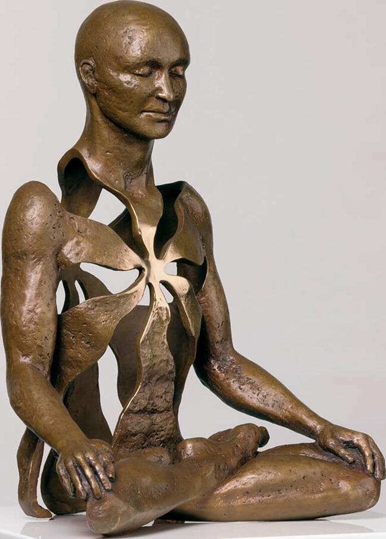 Bronzeskulptur eines meditierenden Menschen mit einer blühenden Öffnung im Bauch