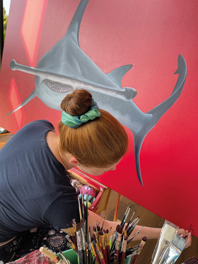 Lea Fricke Künstlerin malt Hammerhead-Shark-Gemälde mit rotem Hintergrund