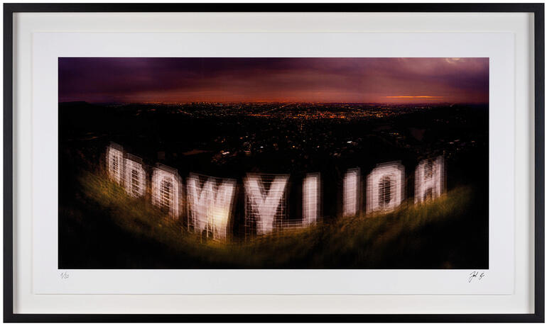 Fotografie von dem Hollywood-Schild in leuchtendem Licht bei Dämmerung.