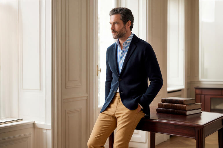 Mann in navyfarbenem Milano-Knit-Sakko in einem eleganten Raum