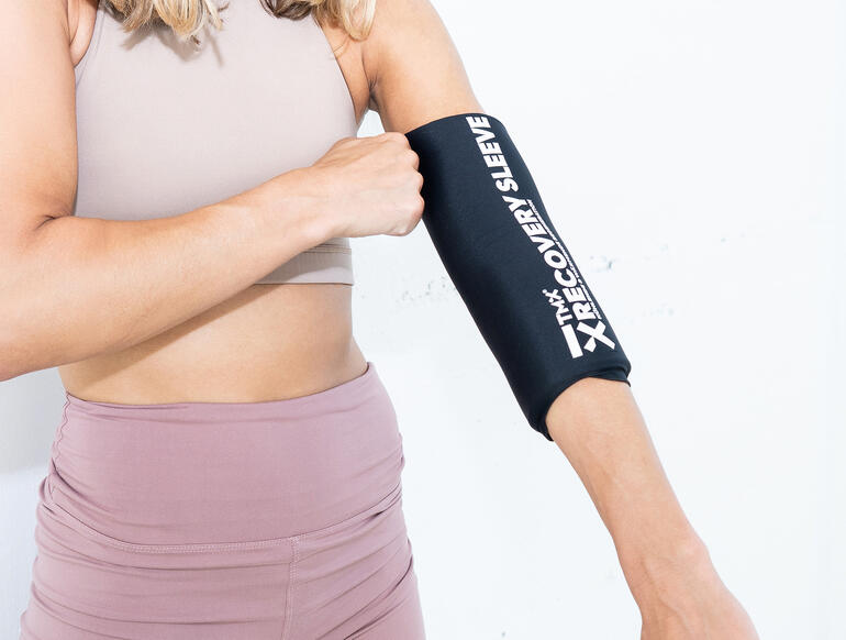 Frau trägt Kälte-/Wärme-Bandage am Arm