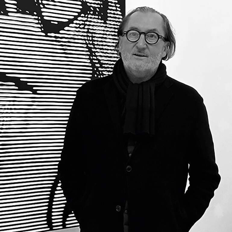 Janos Schaab Janos Schaab steht vor einer Schwarz-Weiß-Kunstinstallation.