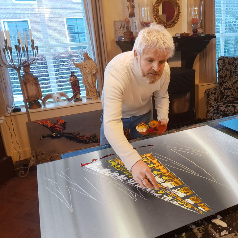 Paul La Poutré malt ein großes Kunstwerk auf einer glänzenden Oberfläche.